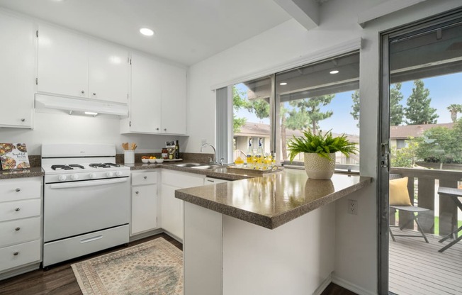 a kitchen with white cabinets and a large window