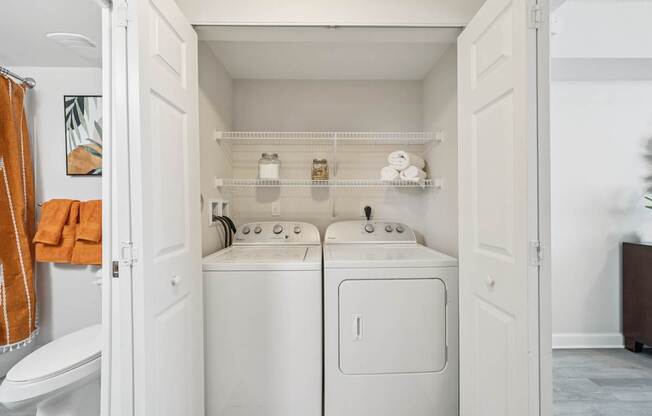 A small laundry room with a towel hanging on the wall.
