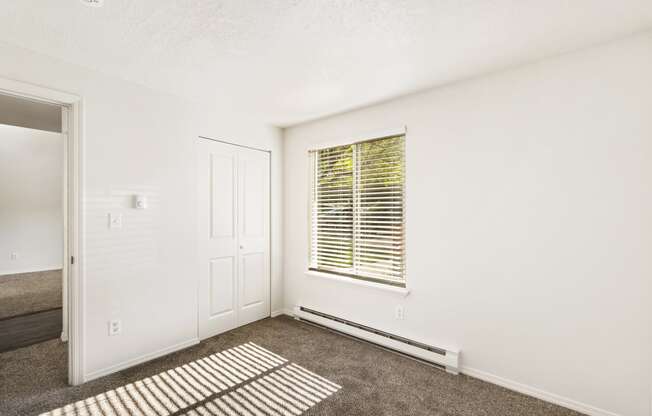 the living room of an apartment with carpet and a window  at Park View Apartments, Wenatchee, Washington