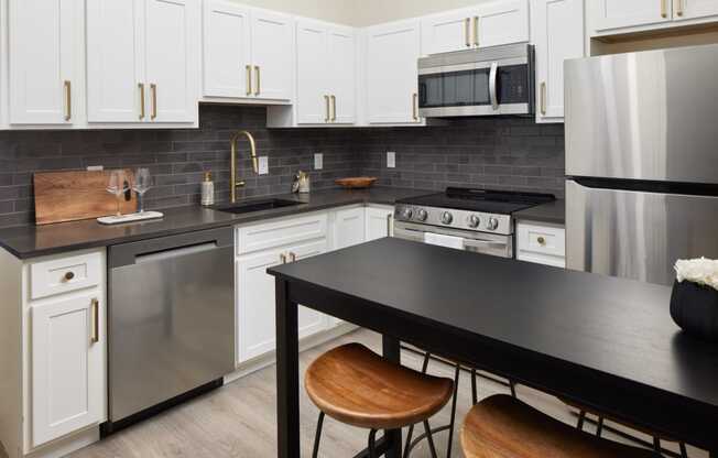 a kitchen with stainless steel appliances and a black counter top