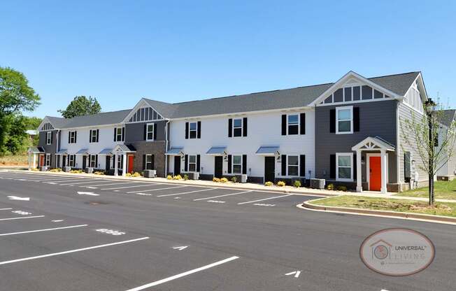 A white and gray apartment building with orange doors.