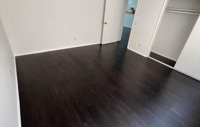 Bedroom with hardwood flooring and large closet at The Carlton in Hollywood, California.