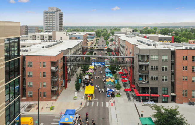 A busy street scene with people walking and cars driving.