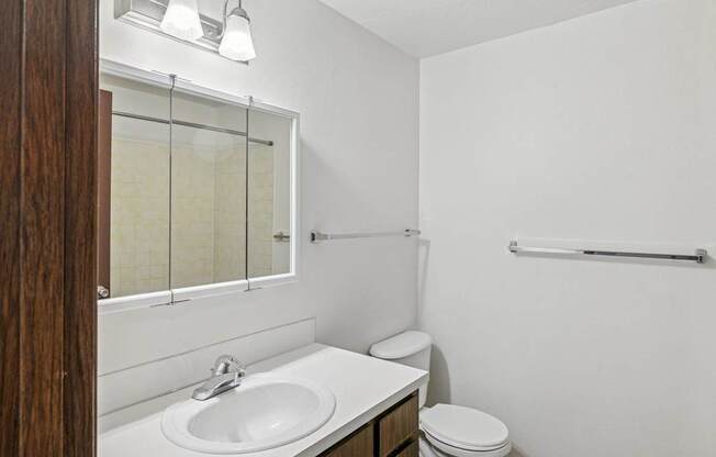 A white sink in a bathroom with a toilet and a towel rack.