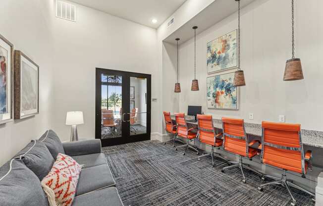 a conference room with a gray couch and orange chairs