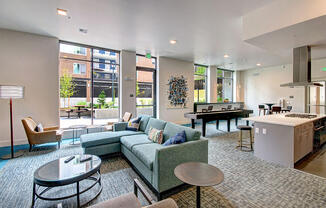 A modern living room with a kitchen area in the background. at Ravello Apartments, Redmond, Washington
