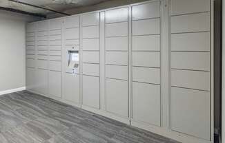 A wall of white lockers in a room.