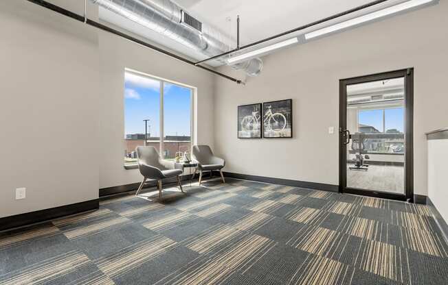 A room with a carpeted floor and a view of the outside through a window.