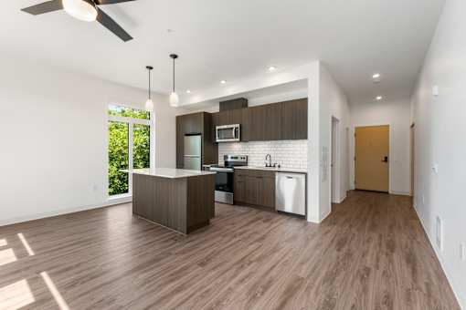 A modern kitchen with a wooden floor and white walls.