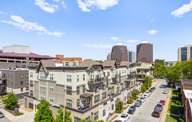 an aerial view of a row of apartment buildings with a city skyline in the background