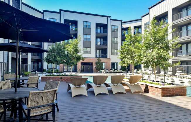 a large patio with tables and chairs and a swimming pool