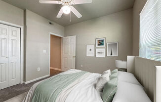 a bedroom with a large bed and a ceiling fan
