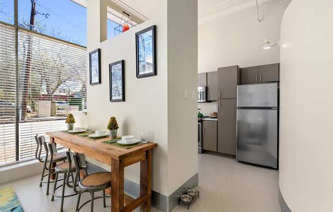 A kitchen with a table and chairs in front of a window.