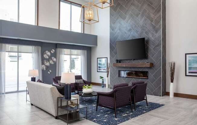 A modern living room with a grey sofa set and a fireplace.