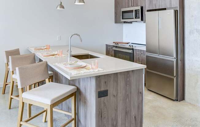 A kitchen with a white countertop and wooden cabinets.