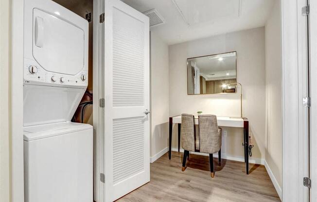 a washer and dryer in a laundry room with a desk and a mirror