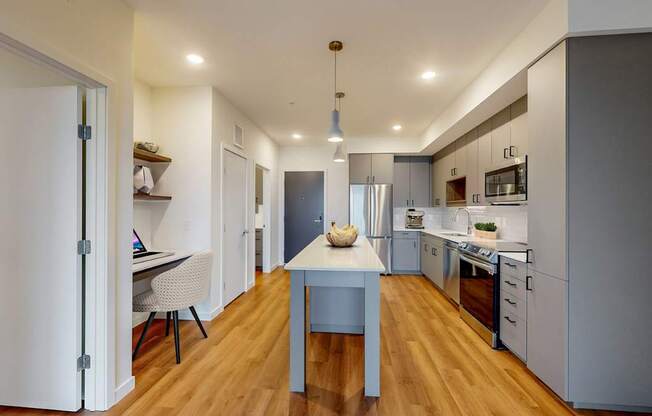 A modern kitchen with a table and chairs in the middle.
