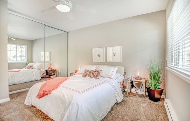 A bedroom with a large bed and a ceiling fan.