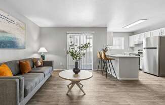 A living room with a grey couch and a white coffee table.