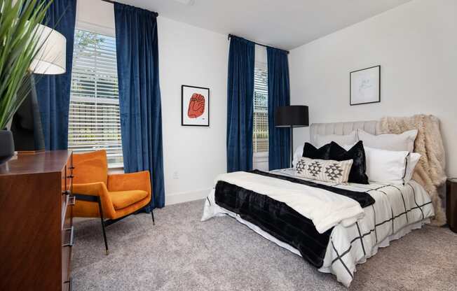 a bedroom with a bed and a desk with a chair at The Quincy Apartments, Acworth, GA, 30102