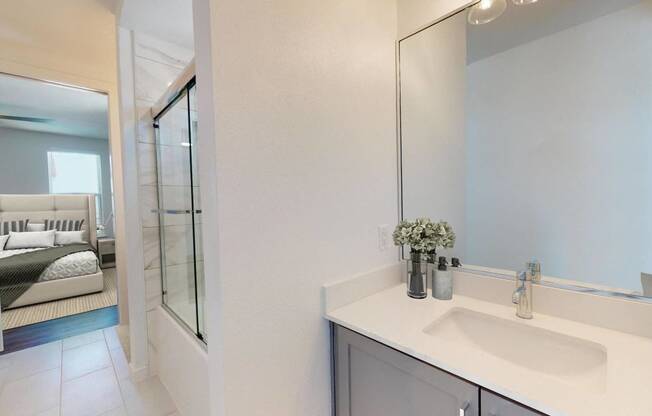 a bathroom with a sink and a shower and a mirror