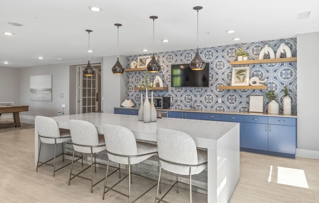 a kitchen with blue cabinets and a white island with chairs