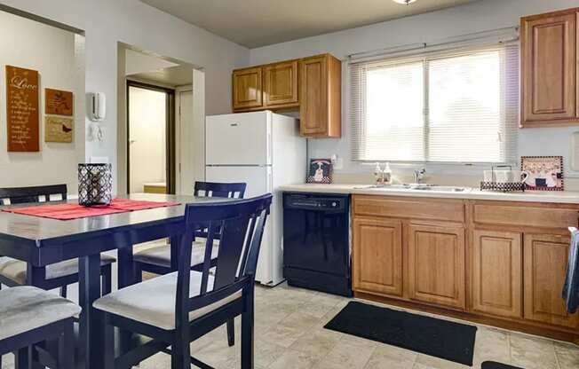 A kitchen with a table and chairs.