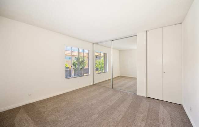 a living room with white walls and flooring and a large window