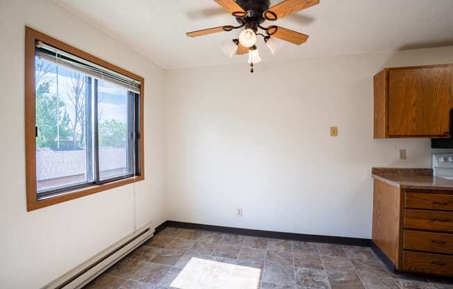 an empty kitchen with a ceiling fan and a window. Fargo, ND Southview Village Apartments