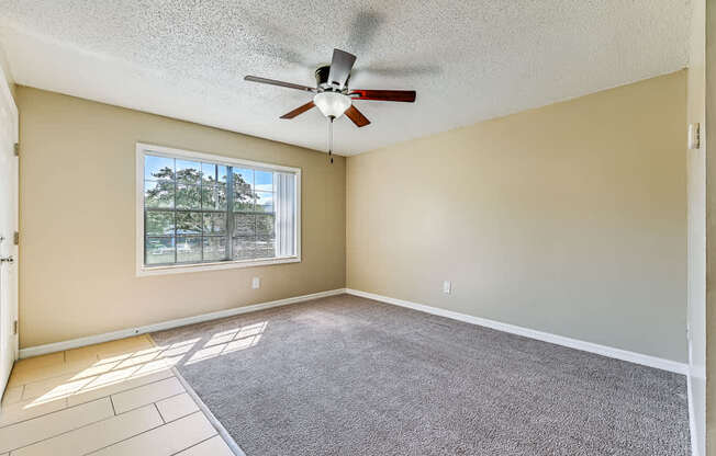 A room with a ceiling fan and a window.
