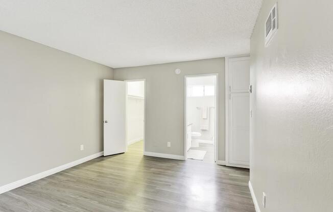 A room with a white door and a grey wall.