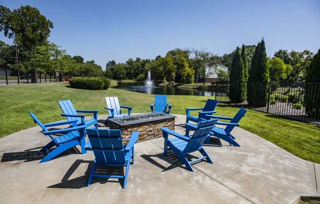 a group of blue chairs sitting around a fire pit