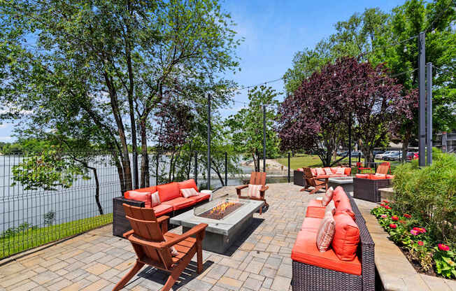 A patio with red couches and a fire pit.