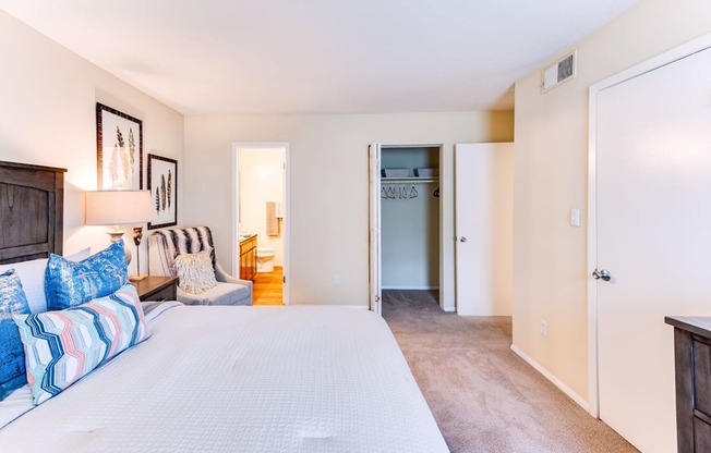 a bedroom with a bed and a chair in a room