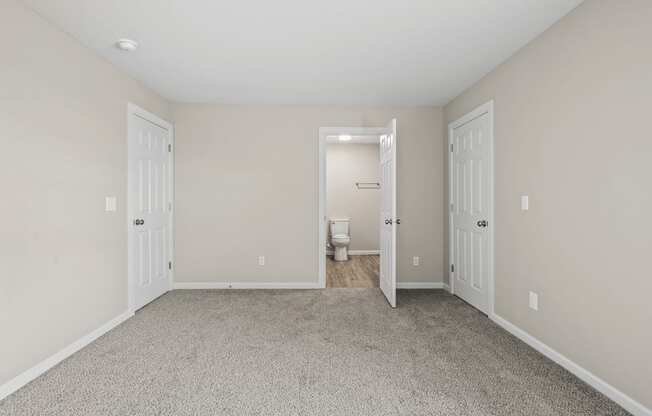 an empty room with two doors to a bathroom and a toilet at Diamond Ridge Townhomes, Oklahoma City Oklahoma