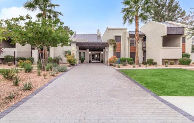 a house with a long walkway and palm trees in front of it