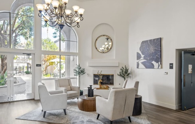 a living room with white furniture and large windows