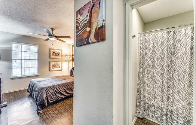 the master bedroom has a ceiling fan and a sliding door to the bathroom