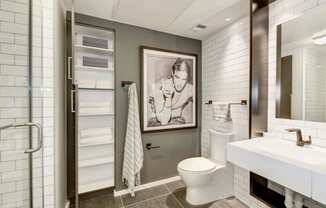 a bathroom with a toilet and a painting on the wall
