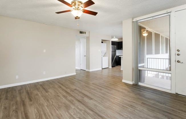 Tempe, AZ Apartments – Sentry Tempe – an empty living room with a ceiling fan and hardwood floors