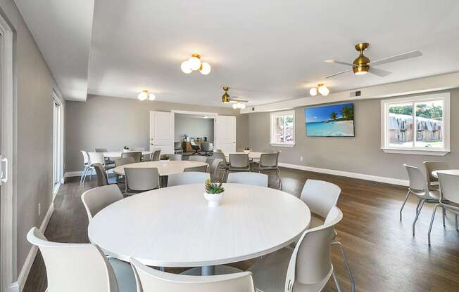 Resident clubhouse with a kitchen, seating, community tables, and bright natural light at Warren Woods Apartments in Warren, MI.