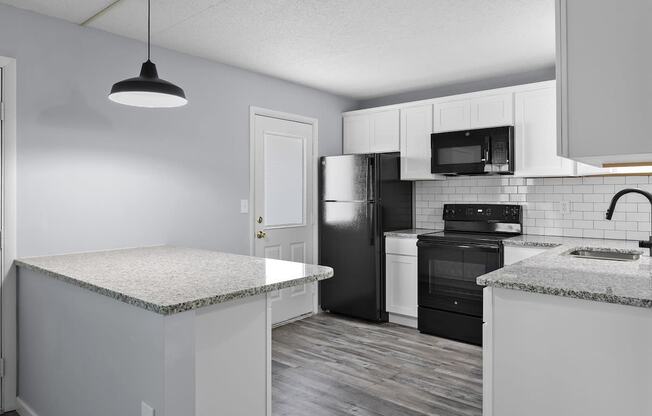 a kitchen with white cabinets and black appliances