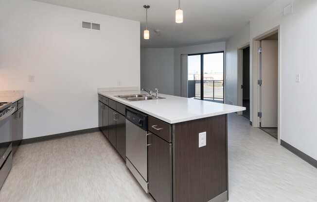 Modern open-concept kitchen and living area with stainless steel appliances.