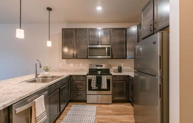 a kitchen with stainless steel appliances and granite countertops. Fargo, ND Prairiewood Meadows