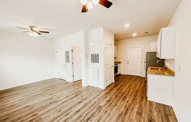 a kitchen and living room with a ceiling fan