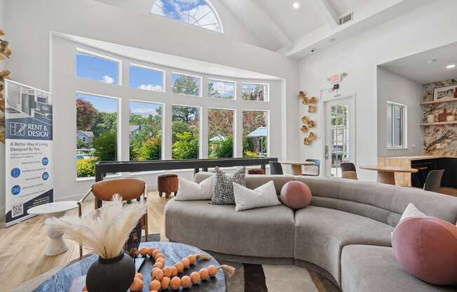 A living room with a grey sofa and a table with a vase and some decorations on it.