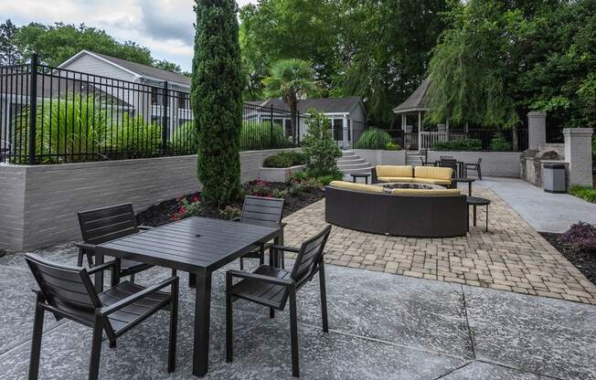 a patio with a table and chairs and a fire pit