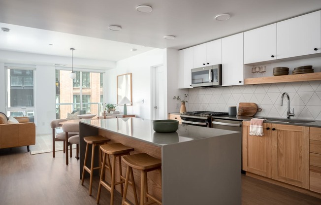 a kitchen with a large island and wooden chairs in a living room at Slabtown Square Apartments, Oregon, 97209