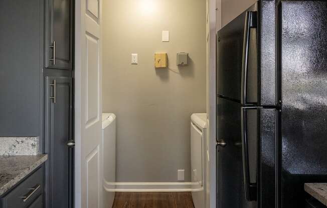 a kitchen with a black refrigerator freezer next to a black and white refrigerator