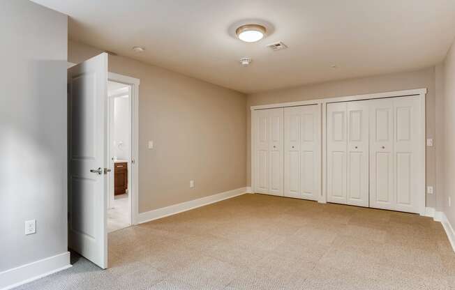 a empty room with two closets and a door to a closet